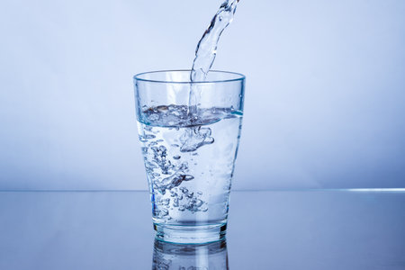 Pouring drink mineral water into a glass pourの写真素材