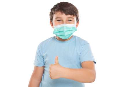 Child kid little boy wearing face mask against virus showing thumbs up Virus isolated on a white backgroundの写真素材