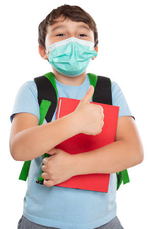 Young student child kid little boy wearing face mask against virus showing thumbs up Virus  isolated on a white background portrait formatの写真素材