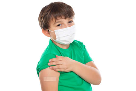 Child kid with plaster after virus vaccination wearing face mask against Virus isolated on a white backgroundの写真素材