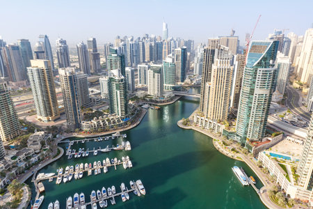 Dubai Marina and Harbor skyline architecture overview wealth luxury travel in United Arab Emirates with boats yacht modernの写真素材