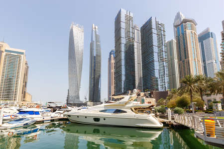 Dubai Marina and Harbor skyline architecture wealth luxury travel in United Arab Emirates with boats yacht modernの写真素材