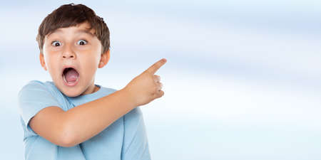 Child kid amazed surprised little boy pointing on ad advertising with copyspace copy space latinの写真素材