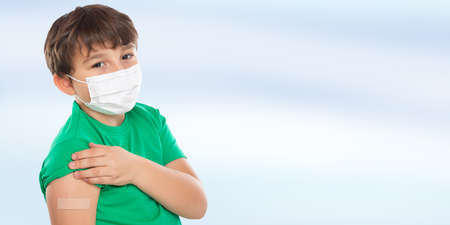 Child kid with plaster after virus vaccination wearing face mask against Virus copy space latinの写真素材