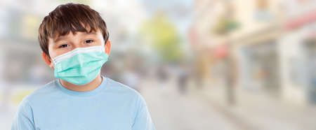 Child kid little boy wearing face mask against  Virus portrait in city town with copyspaceの写真素材