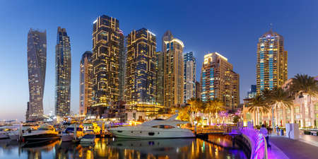 Dubai Marina and Harbor skyline architecture wealth luxury travel with yacht boat at night panorama in United Arab Emirates modernのeditorial素材