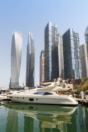 Dubai Marina and Harbor skyline architecture wealth luxury travel in United Arab Emirates with boat yacht portrait format modernのeditorial素材