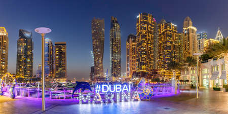 Dubai Marina logo and Harbor skyline architecture wealth luxury travel panorama at night in United Arab Emirates modernのeditorial素材