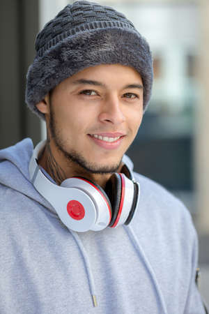 Portrait of a young latin man sports training with headphones winter cold runner outdoorの写真素材