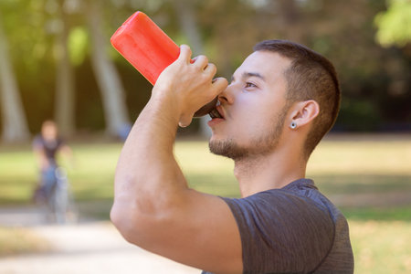 Drinking water runner young man drink jogger sports training fitness workout outdoorの写真素材