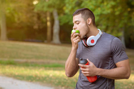 Runner young latin man eating an apple sports training fitness copyspace copy space outdoorの写真素材