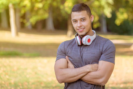 Smiling young latin man runner sports training fitness workout in a park copyspace copy space outdoorの写真素材