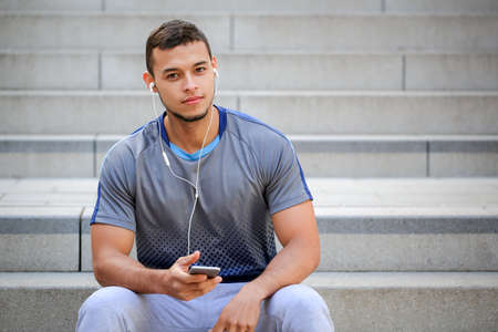 Young latin man listening to music copyspace copy space listen smartphone smart phone outdoorの写真素材