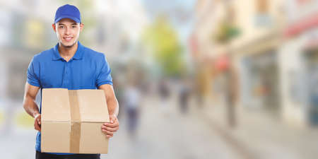 Parcel delivery service box package delivering town banner copyspace copy space job logistics young man outdoorsの写真素材