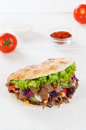 Doner Kebab Doner Kebab fast food in flatbread on a wooden board portrait format snackの写真素材
