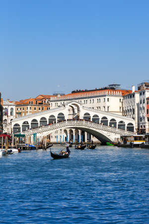 Venice Rialto bridge over Grand Canal with gondola travel traveling holidays vacation city town portrait format in Italyの写真素材