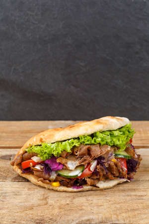 Doner Kebab Doner Kebab fast food in flatbread on a wooden board portrait format snackの写真素材
