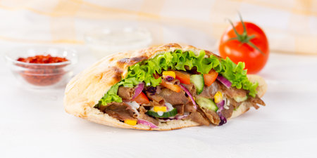 Doner Kebab Doner Kebap fast food in flatbread on a wooden board panorama snackの写真素材
