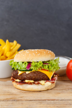 Hamburger Cheeseburger meal fastfood fast food with French Fries on a wooden board portrait format copyspace copy space snackの写真素材