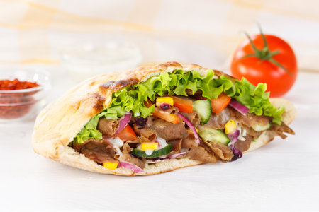 Doner Kebab Doner Kebap fast food in flatbread on a wooden board snackの写真素材
