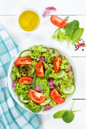 Mixed salad with fresh tomatoes healthy eating food eat from above portrait format on a wooden boardの写真素材