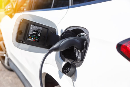 Recharging the battery of an electric car vehicle with green energy at charging station eco powerの写真素材