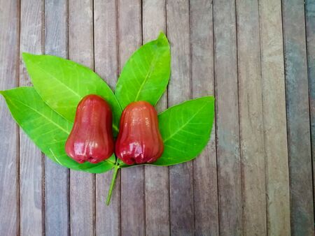 Top view of two rose apple fruit with green leaves on wood table background.の写真素材