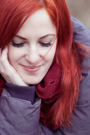 Outdoors portrait of beautiful woman with red hair and closed eyesの写真素材