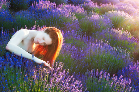 Beautiful red haired woman on lavender fieldの写真素材