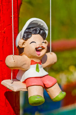 doll on swing in gardenの写真素材