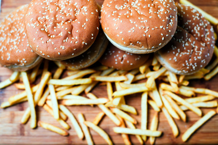 Tasty burger buns with french fries on a wooden backgroundの写真素材