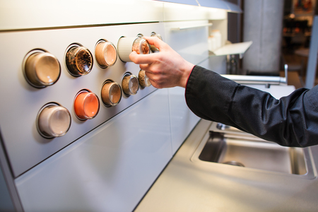 Man's hand is choosing one of the assorted bottles with the ground spices in a kitchenの写真素材