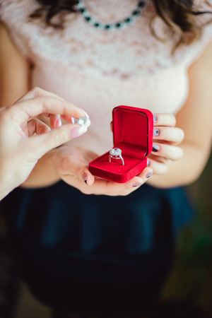 Closeup of a girl holding wedding ring in the red box, wedding jewelryの写真素材