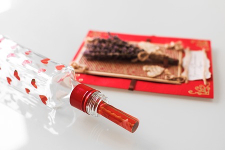 Close-up of a hand-made post card with lavender, hearts and copy space and bottle with hearts and note. Gift, Valentine, Christmas, Birthday, Holiday concept. White backgroundの写真素材