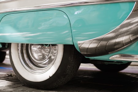 Wheel tyres of blue and white vintage car. Exhibition on streetの写真素材