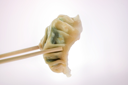 Chinese fresh vegeterian steamed dumplings gyoza with chopsticks on a white background. Isolated. Asian foodの写真素材