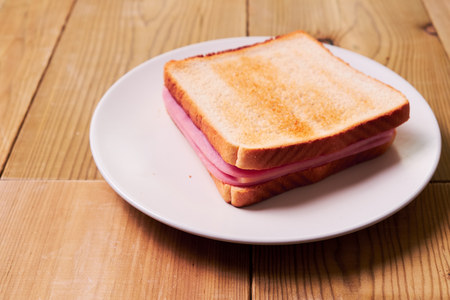 Close-up of fresh sandwich with ham york and cheese on wooden background.の写真素材