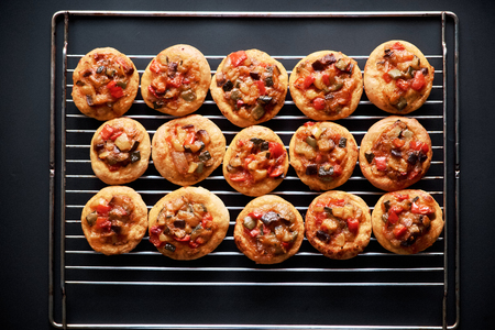 Spanish traditional cocas mini pizzas on black backgroundの写真素材