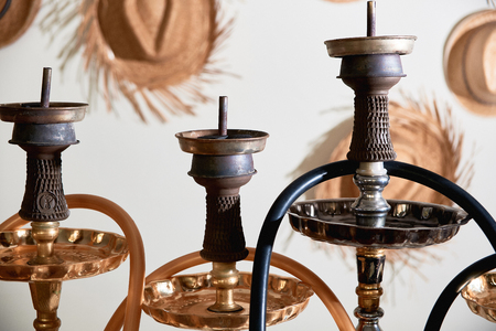 Close-up of hookahs with black pipes on background with straw hats. Shisha smoking concept.の写真素材
