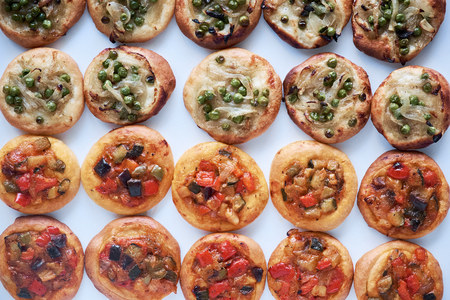Spanish traditional cocas mini pizzas on white backgroundの写真素材