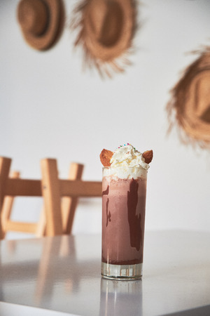Cold chocolate milkshake frappe in glass on table in cafe. Summer sweet drink.の写真素材