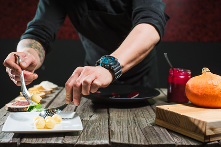 Close-up of male hands cooking modern molecular dish. Dark background. Molecular cuisineの写真素材