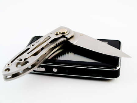 Modern Touchscreen Mobile Phone and Hunting Utility Knife Blade On White Background to Show Cutting Edge of Technology Uses or Utility in Businessの写真素材