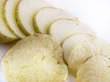 Potato sliced into chips crisps over whiteの写真素材