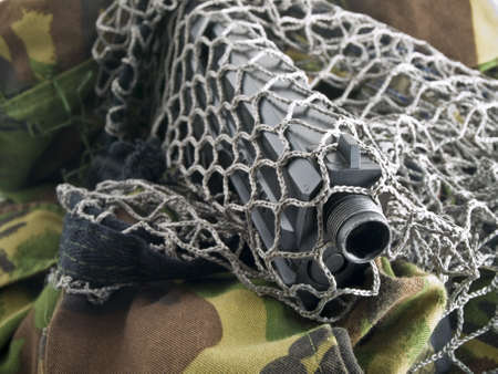 Black Pistol Through Military Net with Camouflageの写真素材