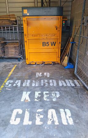 Cardboard baler for recycling and a big keep clear on the ground signの写真素材