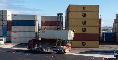 shipping container storage yard a forklift putting a container on a truck in Sydney 05-16-2020 australiaのeditorial素材