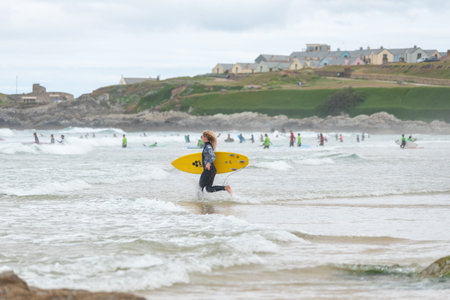 experience blond Surfer girl running into the water at Fistral Beach  , Fistral Beach UKのeditorial素材