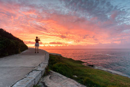 girl take a photo of the beautiful sun rise in the morning  in sydney australiaの写真素材