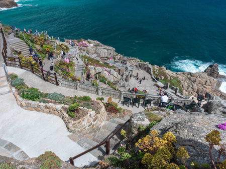 looking down at people walking through minack theatre gardens and carved pathways , cornwall ,  UK...